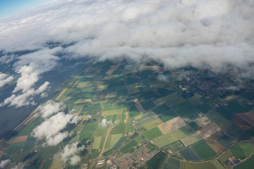 Farms in Holland, Netherlands with canal viewed from plane in sky