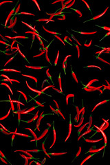 Lots of red hot peppers on a black background