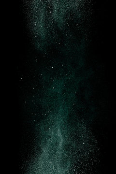Green dust on a black background. Fine particles in motion.