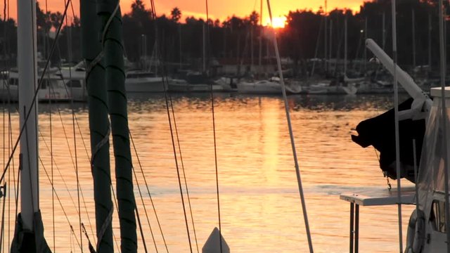 Rack focus shot of rower passing through marina at sunrise