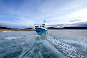 a boat stuck in ice on a lake Khovsgol Nuur