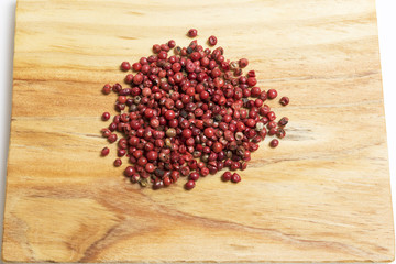 bunch of red peppercorns on a wooden kitchen board
