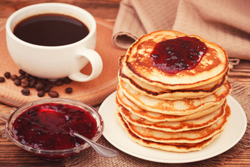 Homemade pancakes with black currant jam and coffee drink