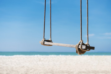 Travel and summer background, wooden swing on the beach with white sand, turquoise water and blue sky. Freedom life relax time. Picture for add text message. Backdrop for design art work.