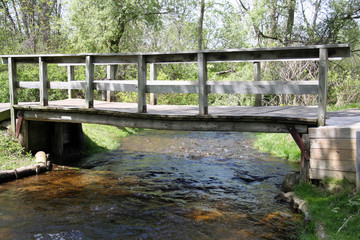 Foot traffic bridge over gentle flowing stream in a city park