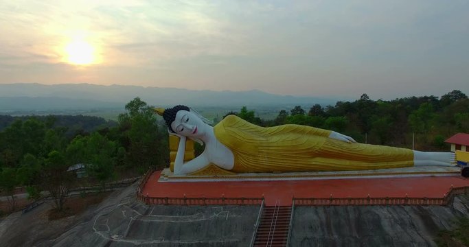 aerial photography sunset above reclining buddha statue at wat Phra That Jom Wae Chiang Rai