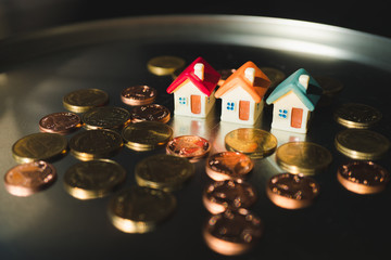 Miniature colorful house with stack coins using as property and financial concept - Vintage filter