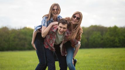 Fun outdoors. Young man and two young woman making fun