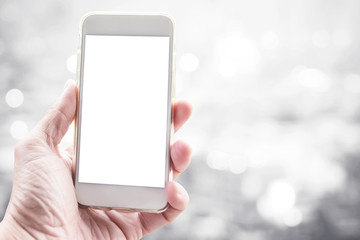 Blank white screen mobile on hand with blurred city light background. Business and technology background concept.