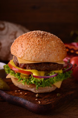 Fresh burger closeup. Wooden rustic background. Top view