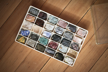 Collection of minerals in box on wooden background