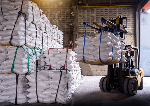 Sugar in bags handling to stacking in warehouse by forklift.