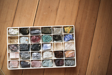 Collection of minerals in box on wooden background