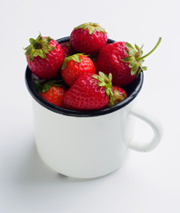Fresh strawberries in enamel mug isolated on white