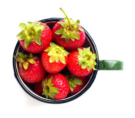 Fresh strawberries in enamel mug isolated on white