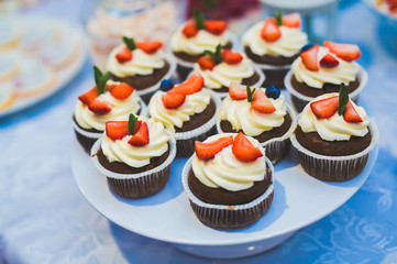 Delicious sweets on wedding candy buffet with desserts, cupcakes