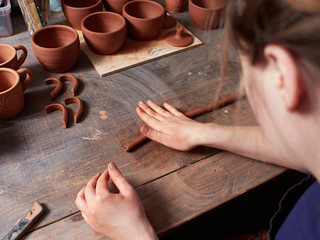 Fototapeta na wymiar production process of pottery. Potter forms a handle for the cup.