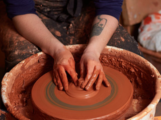 production process of pottery. Forming the clay cover of the kettle on the potter's wheel.