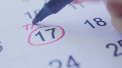 Hand Circling Tax Date on a Calender with Pen