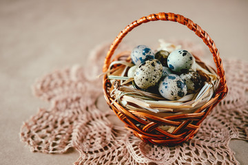 Obraz premium Easter holiday decoration. Quail eggs wrapped in hay in woven basket
