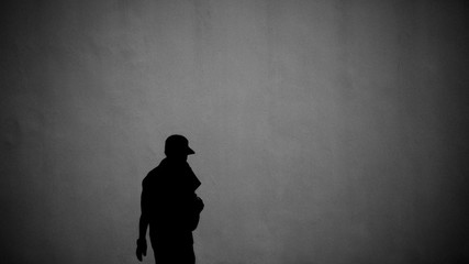 silhouette of a man front the concrete wall - heavy noise and grains background