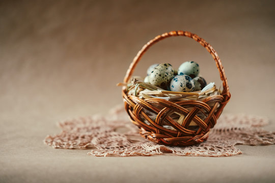 Easter holiday decoration.  Quail eggs wrapped in hay in woven basket