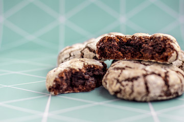 brown cookie with sugar powder on aqua background with white lines