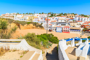 Coastal path to beach in Carvoeiro village with colorful houses, Algarve region, Portugal