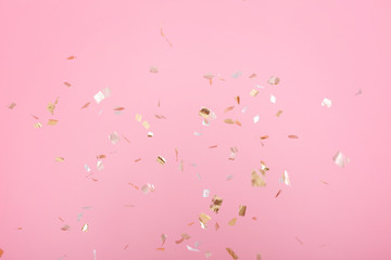 Golden confetti on pink background