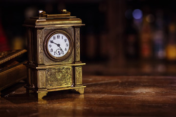 antique clock stand on a wooden table