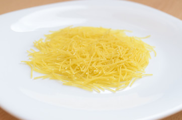 Thin yellow mackerons on a white plate.