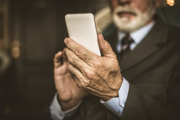 Senior businessman using mobile phone. Close up image.