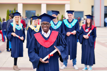 happy african american male college graduate at ceremony