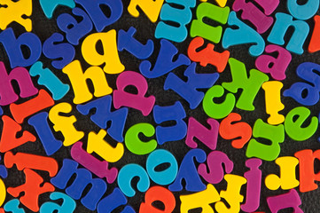 Alphabet plastic letters on the leather background.