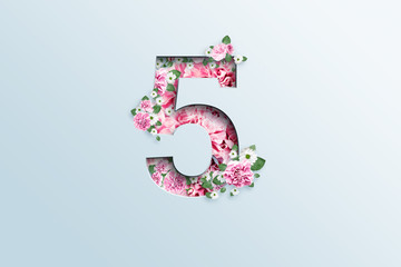 A figure of five consisting of pink flowers and green leaves on a light background. Spring background. flat lay, copy space, Mixed media, top view.