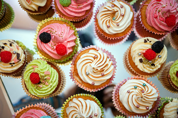 group of tasty cupcakes on a white wooden table