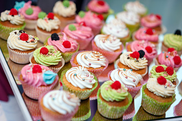 group of tasty cupcakes on a white wooden table
