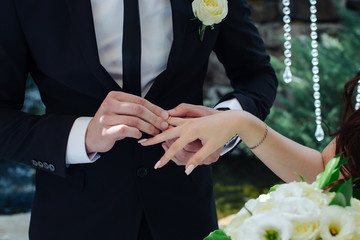 arms with wedding rings of  bride and groom