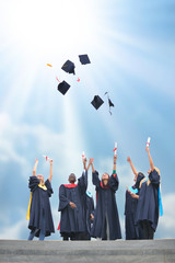 education, graduation and people concept - silhouettes of many happy students in gowns throwing...