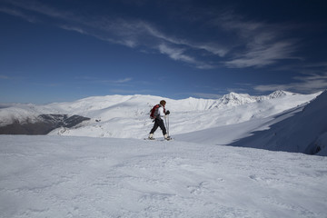 Mujer joven con raquetas de nieve paseando en alta montaña