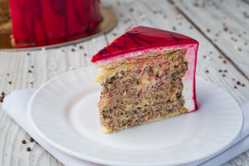 dark chocolate vegan cake with cream and fruit mirror glaze on wooden background