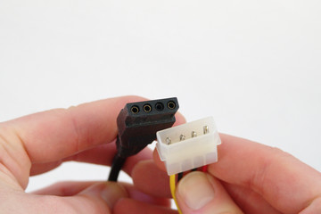 Hands holding 4-pin PC power connectors