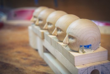 wooden doll heads in a row