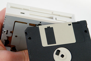 Hand holding 3 1/2 inch FDD Floppy disk drive and one floppy disk removable media