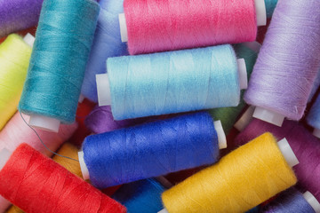 sewing thread in different colors pink blue green red