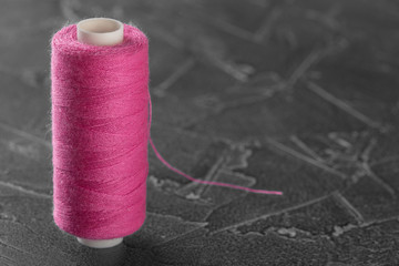 sewing thread on a bobbin of pink color