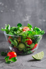 Fresh vegetable salad over textured grey background. The concept of organic vegetarian food. Copy space.