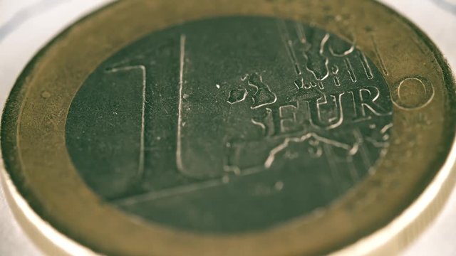Rotating scratched one euro coin, macro shot