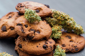 Cookies with cannabis and buds of marijuana on the table. Concept of cooking with cannabis herb....