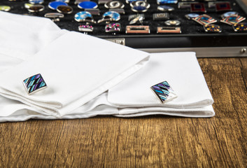 colorful cufflinks on the black and wooden background